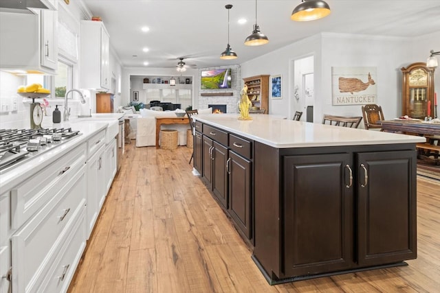 1055 Sumner Grv, Spring Hill, TN 37174 - kitchen featuring a stone fireplace, white cabinets, ceiling fan, open floor plan, and light countertops