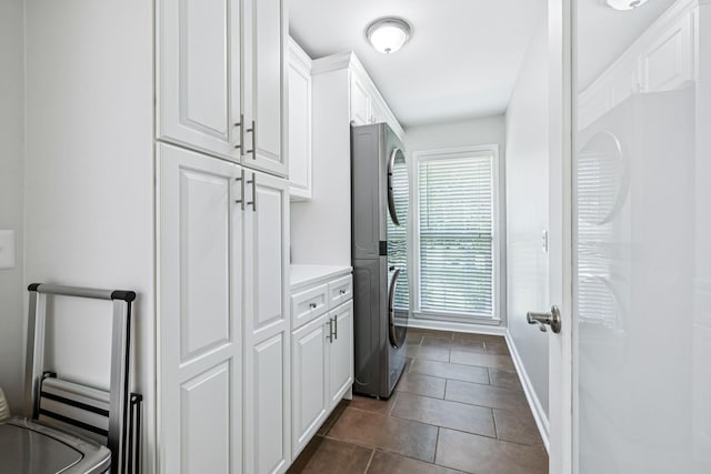 9505 Inavale Ln, Brentwood, TN 37027 - laundry room with estacked washer and dryer, cabinet space, and dark tile patterned floors