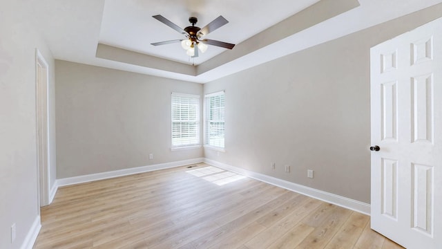 7313 Horn Tavern Ct, Fairview, TN 37062 - spare room with a tray ceiling, light wood-style flooring, and a ceiling fan