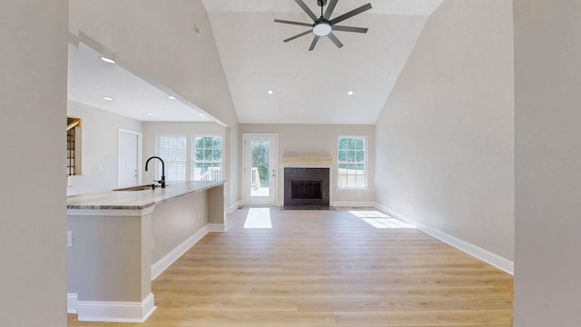 7313 Horn Tavern Ct, Fairview, TN 37062 - unfurnished living room featuring a ceiling fan, light wood-type flooring, a fireplace with flush hearth, high vaulted ceiling, and recessed lighting