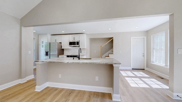 7313 Horn Tavern Ct, Fairview, TN 37062 - kitchen with appliances with stainless steel finishes, a kitchen island with sink, white cabinetry, light wood-style flooring, and recessed lighting