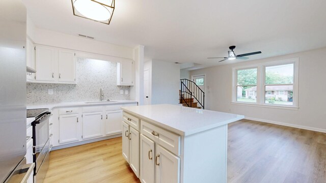 2104 W Richmond Hill Dr, Nashville, TN 37207 - kitchen with stainless steel electric stove, light wood-style flooring, decorative backsplash, a ceiling fan, and light countertops