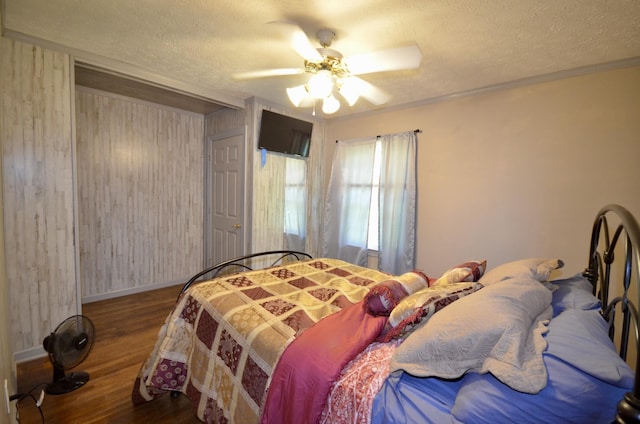 1355 Westfield Rd, Dickson, TN 37055 - bedroom with wooden walls, a textured ceiling, wood finished floors, ceiling fan, and ornamental molding