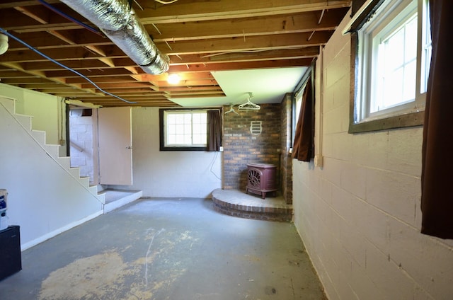 1355 Westfield Rd, Dickson, TN 37055 - below grade area with a wood stove, stairway, and concrete block wall