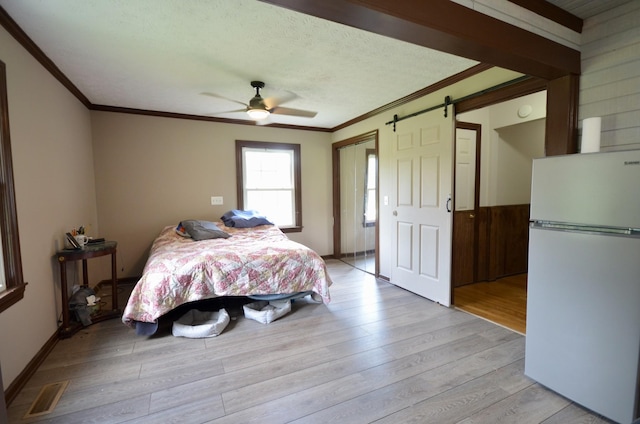 1355 Westfield Rd, Dickson, TN 37055 - bedroom featuring freestanding refrigerator, a barn door, ornamental molding, light wood-style flooring, and ceiling fan