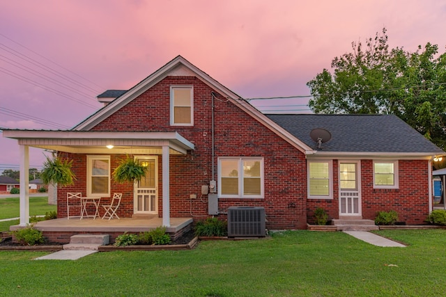1200 Mill St, Pulaski, TN 38478 - view of front of house with covered porch, brick siding, a front yard, entry steps, and roof with shingles
