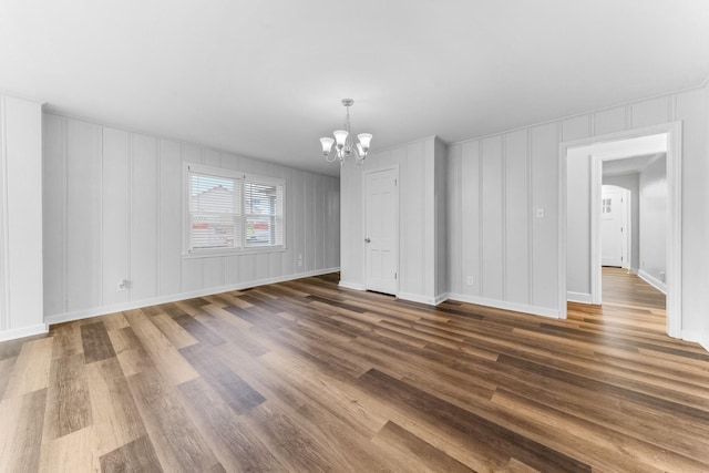 1200 Mill St, Pulaski, TN 38478 - empty room featuring a chandelier, a decorative wall, and dark wood-type flooring