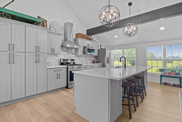1030 Upper Creek Rd, Vanleer, TN 37181 - kitchen featuring appliances with stainless steel finishes, wall chimney exhaust hood, a chandelier, vaulted ceiling, and light wood-style flooring