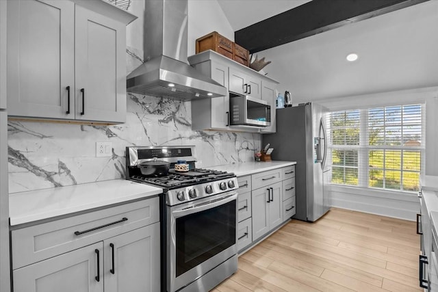 1030 Upper Creek Rd, Vanleer, TN 37181 - kitchen with wall chimney range hood, appliances with stainless steel finishes, light countertops, light wood finished floors, and backsplash