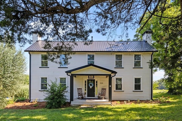 1030 Upper Creek Rd, Vanleer, TN 37181 - view of front of home featuring a chimney, a porch, a front lawn, and a metal roof