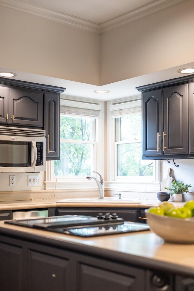 7075 Willowick Dr, Brentwood, TN 37027 - kitchen with stainless steel microwave, light countertops, and crown molding