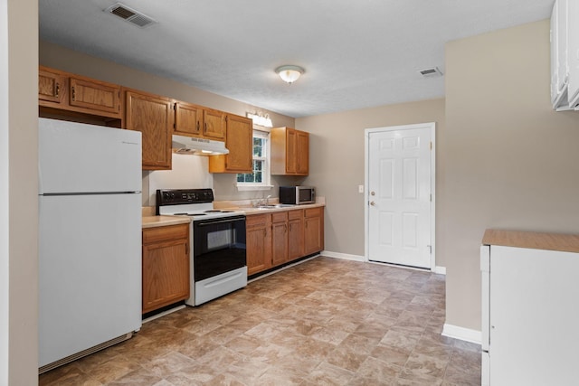 7215 Horn Tavern Rd, Fairview, TN 37062 - kitchen featuring freestanding refrigerator, range with electric stovetop, under cabinet range hood, stainless steel microwave, and light countertops