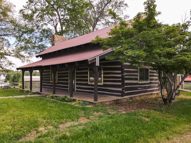 7030 Dodson Branch Rd, Cookeville, TN 38501 - view of home's exterior featuring a metal roof, a lawn, and a chimney