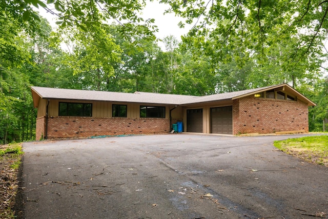 745 Contraband Ln, Cookeville, TN 38501 - view of front of house featuring brick siding, an attached garage, asphalt driveway, and board and batten siding