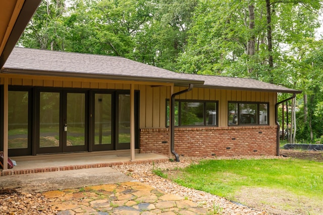 745 Contraband Ln, Cookeville, TN 38501 - view of exterior entry featuring board and batten siding, brick siding, roof with shingles, french doors, and a yard