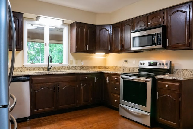 745 Contraband Ln, Cookeville, TN 38501 - kitchen featuring stainless steel appliances, dark brown cabinetry, wood finished floors, and light stone countertops