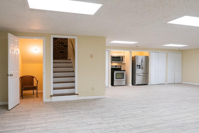 745 Contraband Ln, Cookeville, TN 38501 - unfurnished living room with a textured ceiling, stairs, a skylight, and light wood-type flooring