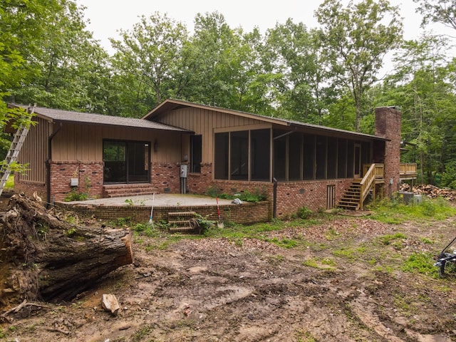 745 Contraband Ln, Cookeville, TN 38501 - view of front of home featuring a sunroom, brick siding, stairway, a chimney, and a patio area