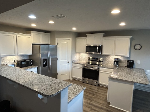 4437 Sunday Silence Way, Murfreesboro, TN 37128 - kitchen with stainless steel appliances, a peninsula, white cabinets, recessed lighting, and decorative backsplash