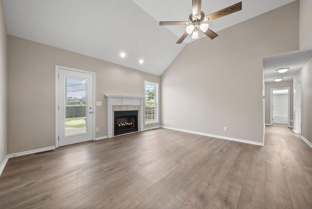 3798 Bret Dr, Clarksville, TN 37040 - unfurnished living room with a tiled fireplace, wood finished floors, a ceiling fan, and high vaulted ceiling