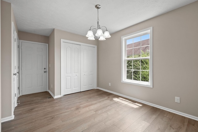 3798 Bret Dr, Clarksville, TN 37040 - unfurnished dining area with light wood finished floors, a chandelier, and a textured ceiling