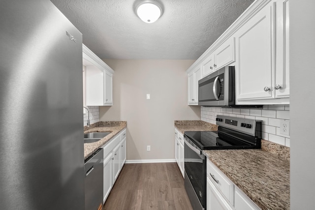 3798 Bret Dr, Clarksville, TN 37040 - kitchen with stainless steel appliances, dark wood-type flooring, tasteful backsplash, white cabinetry, and light stone counters