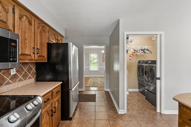 915 Rocky Hollow Rd, Erin, TN 37061 - kitchen with stainless steel appliances, independent washer and dryer, backsplash, light tile patterned floors, and light countertops