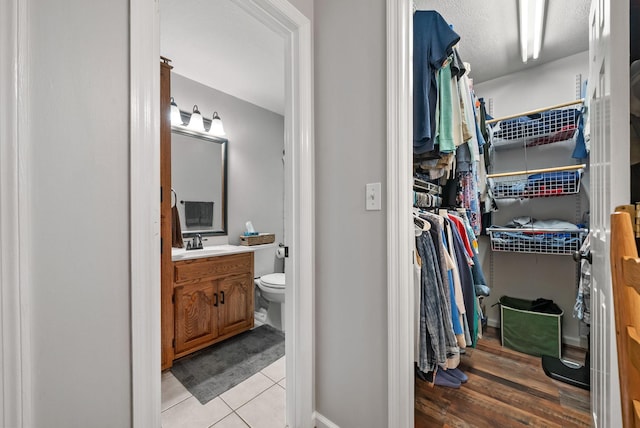 915 Rocky Hollow Rd, Erin, TN 37061 - bathroom with vanity, a walk in closet, and tile patterned flooring