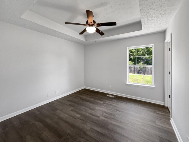 147 Greystone Dr, Springfield, TN 37172 - spare room with a tray ceiling, dark wood-style floors, ceiling fan, and a textured ceiling