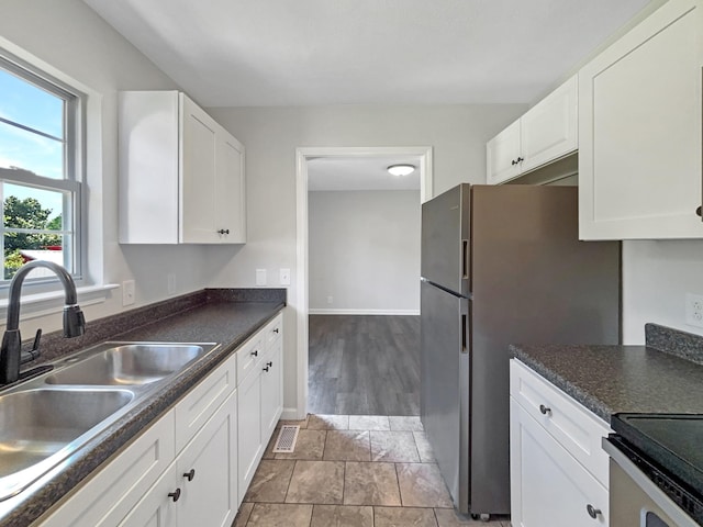 147 Greystone Dr, Springfield, TN 37172 - kitchen featuring white cabinets, dark countertops, freestanding refrigerator, and stove