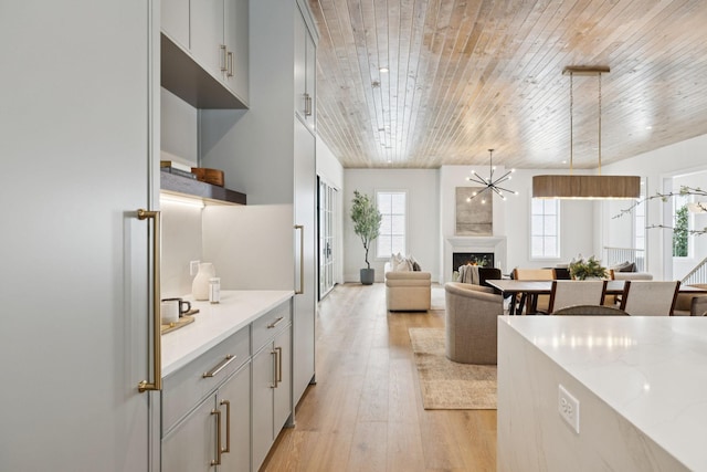 6315 Callie Ln, Brentwood, TN 37027 - kitchen with gray cabinetry, light wood-type flooring, wooden ceiling, a chandelier, and a fireplace
