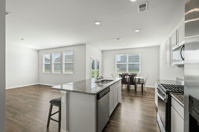 830 Long Leaf Rd, Lebanon, TN 37087 - kitchen featuring appliances with stainless steel finishes, dark wood-style flooring, light stone counters, recessed lighting, and an island with sink