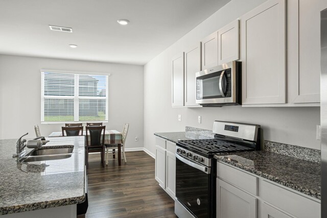 830 Long Leaf Rd, Lebanon, TN 37087 - kitchen with appliances with stainless steel finishes, dark stone countertops, dark wood-type flooring, recessed lighting, and white cabinets