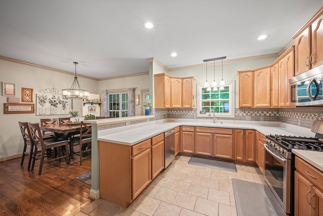 116 Sherrolyn Ct, Burns, TN 37029 - kitchen with appliances with stainless steel finishes, decorative backsplash, a peninsula, a chandelier, and crown molding