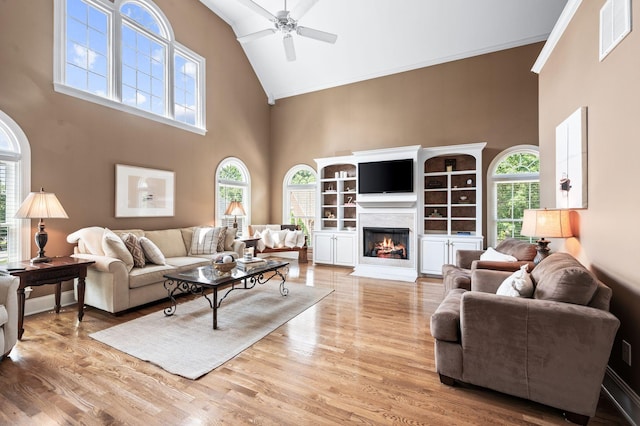9732 Turnbridge Ct, Brentwood, TN 37027 - living room featuring high vaulted ceiling, healthy amount of natural light, a ceiling fan, wood finished floors, and a lit fireplace