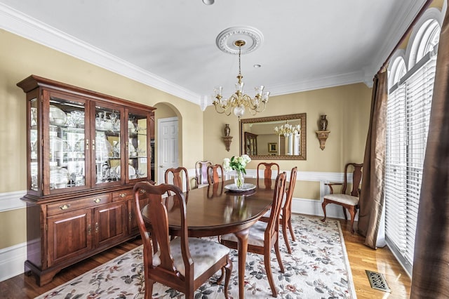 9732 Turnbridge Ct, Brentwood, TN 37027 - dining room featuring a chandelier, crown molding, arched walkways, and light wood-style flooring