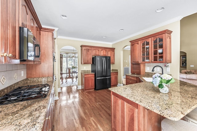 9732 Turnbridge Ct, Brentwood, TN 37027 - kitchen featuring arched walkways, freestanding refrigerator, black gas cooktop, dark wood finished floors, and ornamental molding