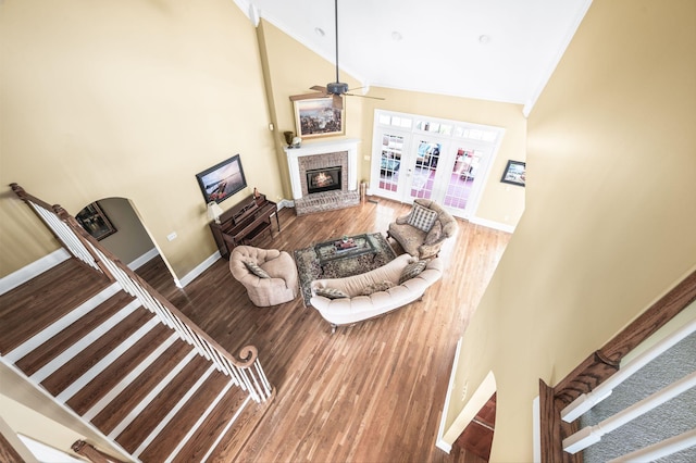 9732 Turnbridge Ct, Brentwood, TN 37027 - living room featuring a brick fireplace, ceiling fan, wood finished floors, high vaulted ceiling, and crown molding