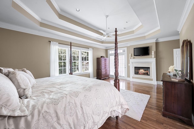 9732 Turnbridge Ct, Brentwood, TN 37027 - bedroom featuring a raised ceiling, a warm lit fireplace, dark wood-type flooring, and ornamental molding