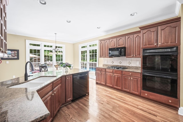 9732 Turnbridge Ct, Brentwood, TN 37027 - kitchen featuring black appliances, light stone countertops, light wood finished floors, crown molding, and decorative backsplash