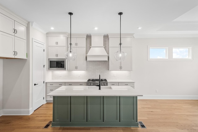 7428 Leelee Dr, Franklin, TN 37064 - kitchen with stainless steel microwave, white cabinets, light countertops, tasteful backsplash, and light wood finished floors
