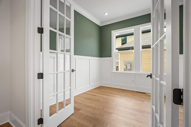 7428 Leelee Dr, Franklin, TN 37064 - spare room featuring light wood-style flooring, crown molding, wainscoting, a decorative wall, and french doors
