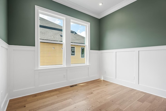 7428 Leelee Dr, Franklin, TN 37064 - spare room with a decorative wall, light wood-type flooring, crown molding, and wainscoting