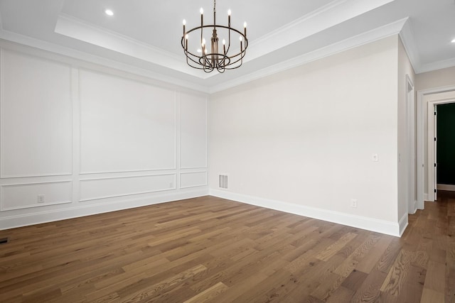 7428 Leelee Dr, Franklin, TN 37064 - empty room with a chandelier, ornamental molding, wood finished floors, a decorative wall, and a tray ceiling