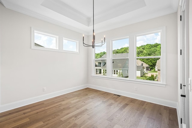 7428 Leelee Dr, Franklin, TN 37064 - unfurnished dining area featuring a raised ceiling, a chandelier, healthy amount of natural light, wood finished floors, and crown molding