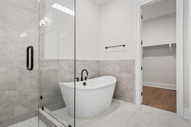 7428 Leelee Dr, Franklin, TN 37064 - bathroom featuring a spacious closet, a shower stall, a freestanding tub, tile walls, and wainscoting