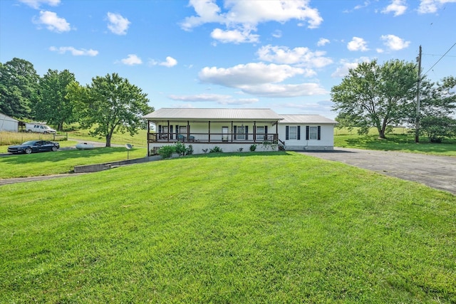 3135 Mullins Rd, Byrdstown, TN 38549 - view of front of home featuring a front yard, a porch, driveway, and a metal roof