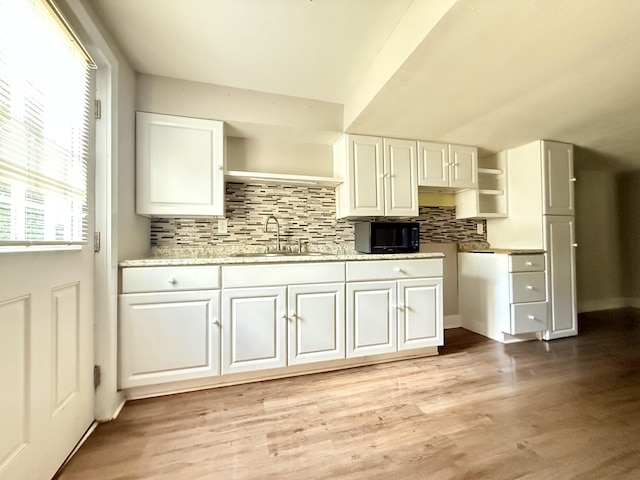 2844 Jarman Hollow Rd, Palmyra, TN 37142 - kitchen with black microwave, white cabinets, and backsplash