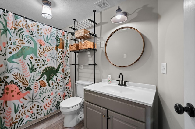 909 W 1st St, Dickson, TN 37055 - full bathroom featuring vanity, wood finished floors, a shower with curtain, and a textured ceiling