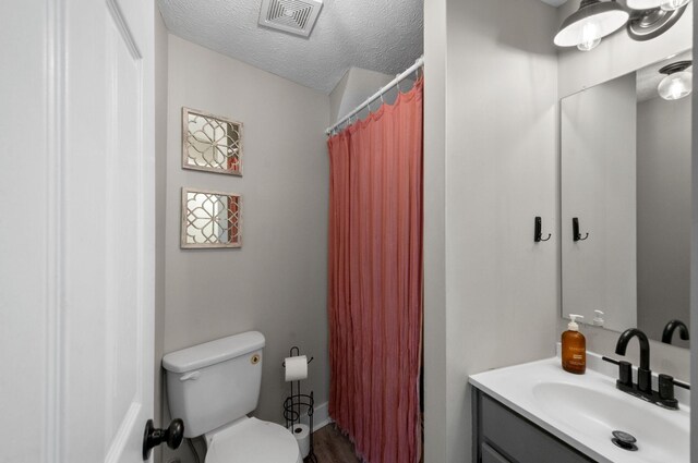 909 W 1st St, Dickson, TN 37055 - full bath featuring vanity, a textured ceiling, a shower with curtain, and wood finished floors